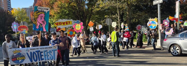 Neighbors march through Forest Hills carrying the VOTEFEST banner and colorful handmade signs.